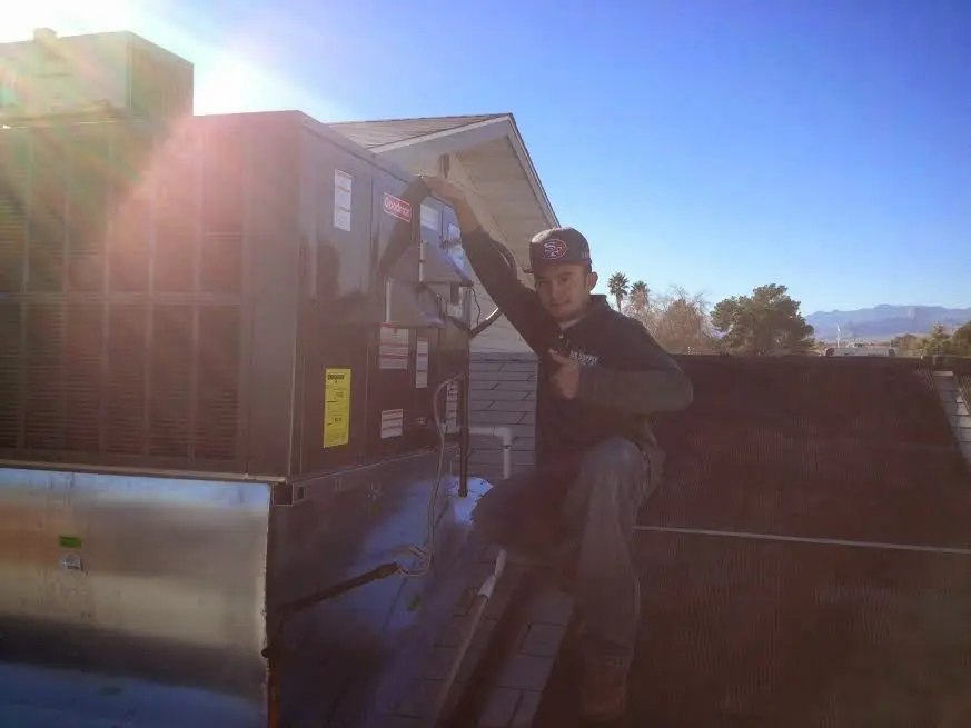 HVAC technician performing AC Tune-Up on a rooftop unit in Northvale